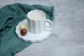 White chocolate hot drink with a pralines in a white mug, grey table Royalty Free Stock Photo