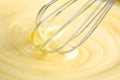 White Chocolate mixing with a whisk. Pouring melted liquid premium milk white chocolate. Close up of molten liquid hot chocolate Royalty Free Stock Photo