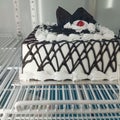 A white chocolate motif birthday cake placed in the refrigerator