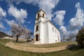 White christian chapel in Pecs with blooming almond tree in spring