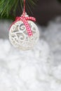 A white Christmas ball and a snow-covered tree branch on a snowy white background. Vertical card place for copy space Royalty Free Stock Photo