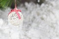 A white Christmas ball and a snow-covered tree branch on a snowy white background. Horizontal card place for copy space Royalty Free Stock Photo