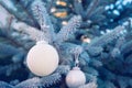 White Christmas balls on a Christmas tree branch, closeup, soft selective focus, banner. Royalty Free Stock Photo