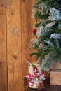 White Christmas candle holder decorated with pine cone and ashberry stick under Christmas tree on wooden table. Royalty Free Stock Photo