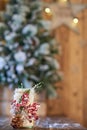 White Christmas candle holder decorated with pine cone and ashberry stick under Christmas tree on wooden table Royalty Free Stock Photo