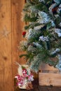 White Christmas candle holder decorated with pine cone and ashberry stick under Christmas tree on wooden table. Royalty Free Stock Photo