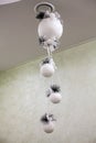 White Christmas decorations in the form of balls on a ribbon hang on the ceiling Royalty Free Stock Photo