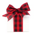 White Christmas gift box with red and black buffalo plaid bow and ribbon isolated on white Royalty Free Stock Photo