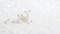 White Christmas greeting card. Two deer in snow on white background with Christmas balls and bokeh. Monochrome winter Royalty Free Stock Photo