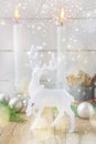 White Christmas New years composition with deer lit candles fir tree branches balls cinnamon pine cones on wood Royalty Free Stock Photo