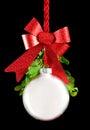 White Christmas ornament hanging by red ribbon rope with the bauble surrounded with green mistletoe Royalty Free Stock Photo