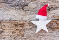 White Christmas star with red Santa hat on old wooden background with copy space Royalty Free Stock Photo