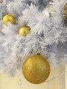 White Christmas tree decoration closed up glitter golden ball ornaments with white tinsel background Royalty Free Stock Photo
