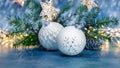White christmas tree glass balls near green christmas tree branch on blue bokeh background Royalty Free Stock Photo