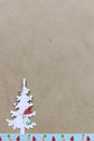 White Christmas tree made of paper on brown craft paper background