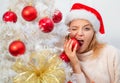 White christmas tree red balls. Beautiful Woman in Santa Hat at Home. We wish you a merry christmas tree, elegant party Royalty Free Stock Photo