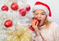 Woman in snow. White christmas tree red balls. Beautiful Woman in Santa Hat at Home. We wish you a merry christmas tree Royalty Free Stock Photo