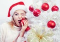 White christmas tree red balls. Beautiful Woman in Santa Hat at Home. We wish you a merry christmas tree, elegant party Royalty Free Stock Photo