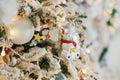 White Christmas tree with vintage toys, toy bear, balls, garlands on a spruce branches with artificial snow, copy space Royalty Free Stock Photo