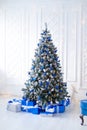 White christmas tree on white, decorated with blue ornaments and garland, lots of presents under the tree Royalty Free Stock Photo