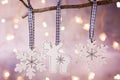 White Christmas Wood Ornaments Reindeer Snow Flakes Hanging on Tree Branch. Sparkling Garland Lights Pastel Color Background. Royalty Free Stock Photo