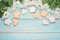 White chrysanthemums on a wooden background with homemade cookies in the form of hearts and flowers, with an empty space for writi