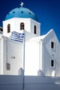 White church with blue dome and Greek flag, Santorini Royalty Free Stock Photo