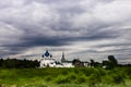 White church with blue domes under a stormy sky. Royalty Free Stock Photo