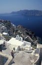 White church with clocktowers and houses in Oia on volcanic island of Santorini