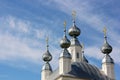 White Church with five domes with Golden crosses and blue sky