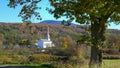 White church at stowe framed by tree and a hill with fall foliage Royalty Free Stock Photo