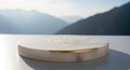 A white circular object on a table with mountains in the background Royalty Free Stock Photo