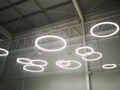 White circular ring shaped lamps hang under a concrete ceiling Royalty Free Stock Photo