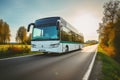 A white city bus journeys through Polands scenic countryside on a cloudy day