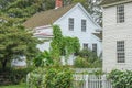 White clapboard houses with picket fences and flowers and vines growing up on them Royalty Free Stock Photo