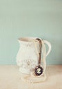 White classic victorian vase on wooden table with a collection of romantic vintage jewelry and pearls. retro filtered image. room Royalty Free Stock Photo