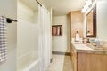 White clean bathroom interior with modern maple cabinets