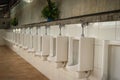 White clean ceramic urinal bowls in the public men's toilet. Row Royalty Free Stock Photo