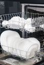 White, clean cups and plates in an open dishwasher Royalty Free Stock Photo