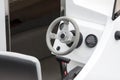 White clean new yacht, motorboat interior, steering wheel and captains chair cockpit closeup