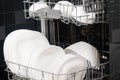 White clean plates in the dishwasher, background, side view Royalty Free Stock Photo
