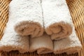 White clean rolled terry towel stack on wicker basket background. Close up Royalty Free Stock Photo