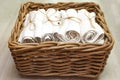 White clean rolled terry towel stack in wicker basket on natural wooden background. Close up Royalty Free Stock Photo