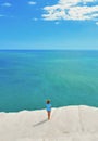 White cliffs naturally made of smooth pug at Scala dei Turchi beach with lonely woman with turquoise mediterranean sea