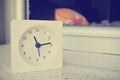 White clock next to an empty bed, retro/vintage