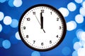 The white clock shows five seconds to midnight, on the bokeh background. Countdown to the new year Royalty Free Stock Photo