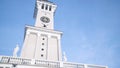 White Clock Tower On Background Of Blue Sky. Action. Bottom View Of Beautiful White Clock Tower On Background Of Sky