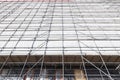 white cloth and metal poles of scaffolding against high new building Royalty Free Stock Photo