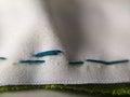 white cloth sewing blue thread