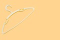 A white clothes hanger is empty without clothes on orange background Royalty Free Stock Photo